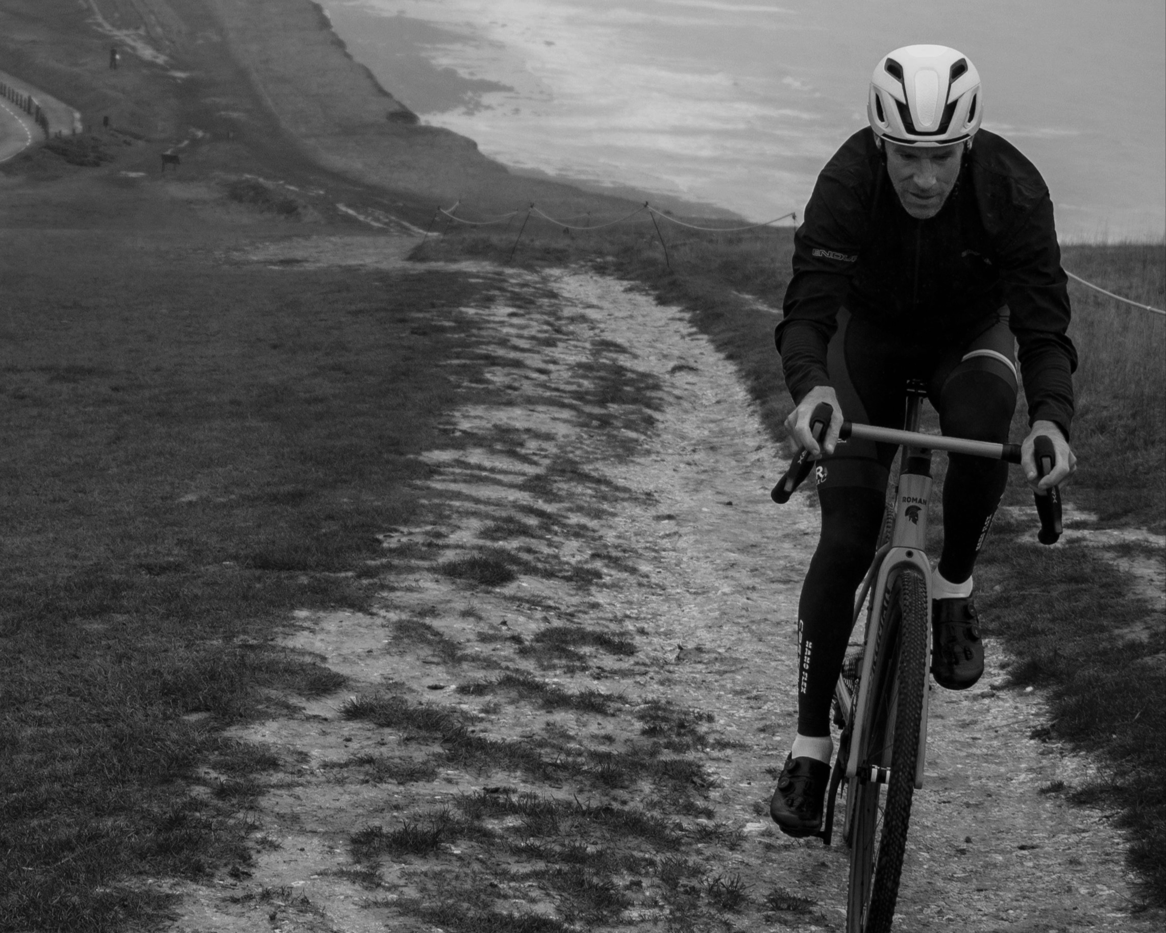 Cyclist riding on a coastal path with cliffs in the background